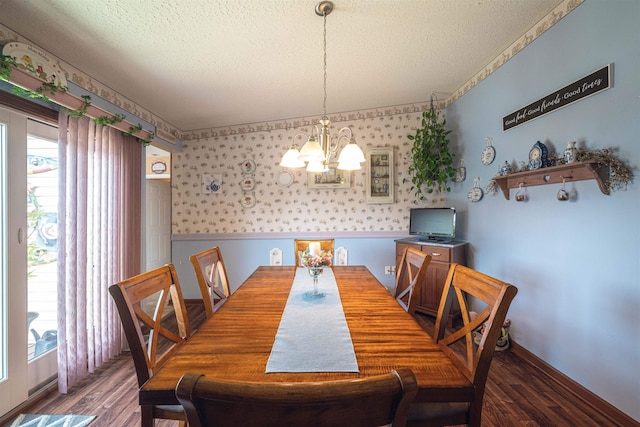 dining room featuring dark hardwood / wood-style flooring, a textured ceiling, and a notable chandelier