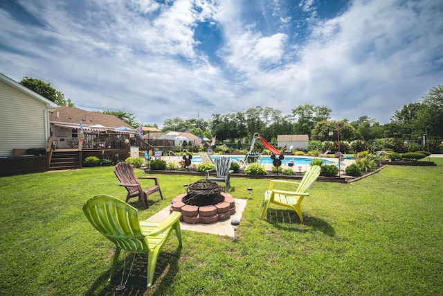 view of yard with an outdoor fire pit and a pool side deck