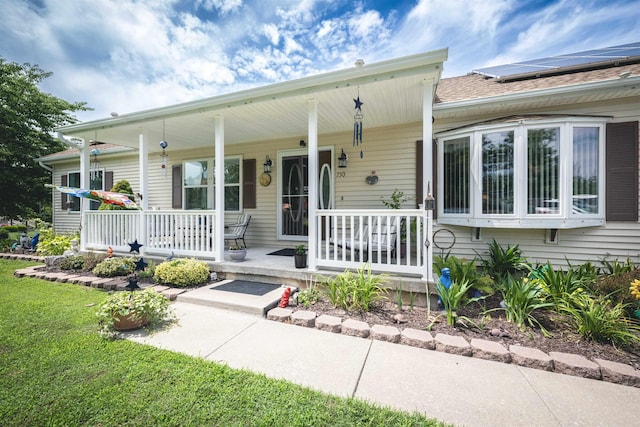 view of front facade with solar panels and a porch