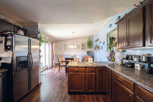 kitchen with stainless steel fridge, a textured ceiling, decorative light fixtures, kitchen peninsula, and a chandelier