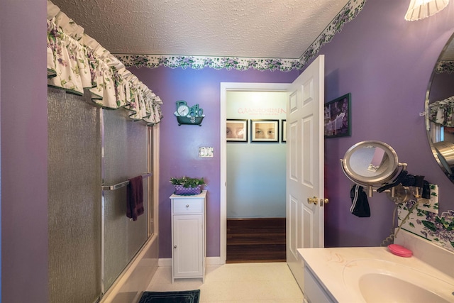 bathroom with vanity, a textured ceiling, and an enclosed shower