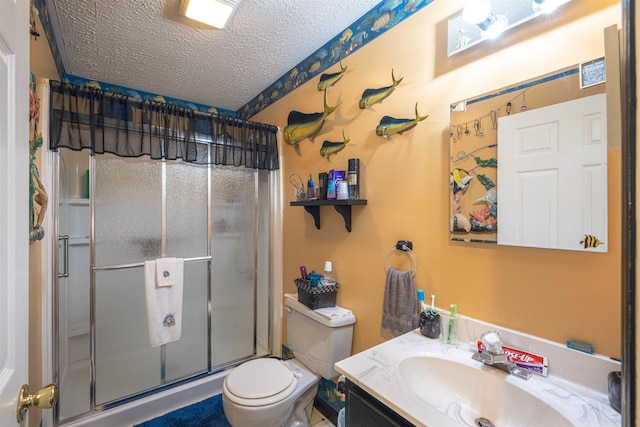 bathroom with vanity, a textured ceiling, toilet, and walk in shower