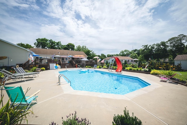 view of swimming pool featuring a patio and a water slide