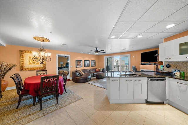 kitchen featuring white cabinetry, dishwasher, sink, hanging light fixtures, and ceiling fan with notable chandelier