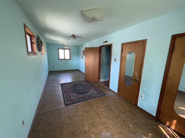 interior space featuring baseboards and a ceiling fan