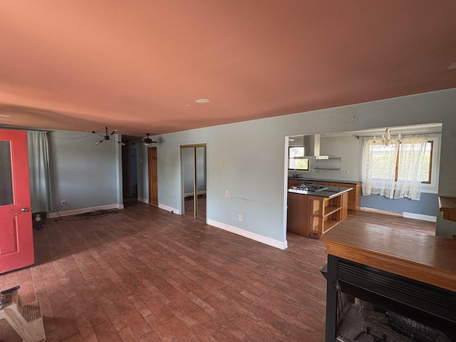 unfurnished living room featuring baseboards and dark wood-style flooring