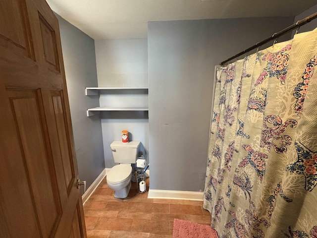 full bath featuring baseboards, curtained shower, and toilet