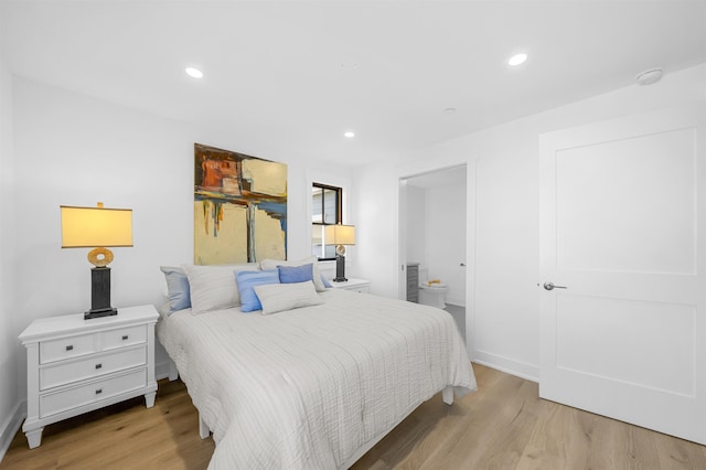 bedroom featuring connected bathroom and light wood-type flooring