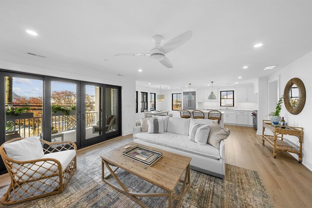 living room with light hardwood / wood-style floors and ceiling fan