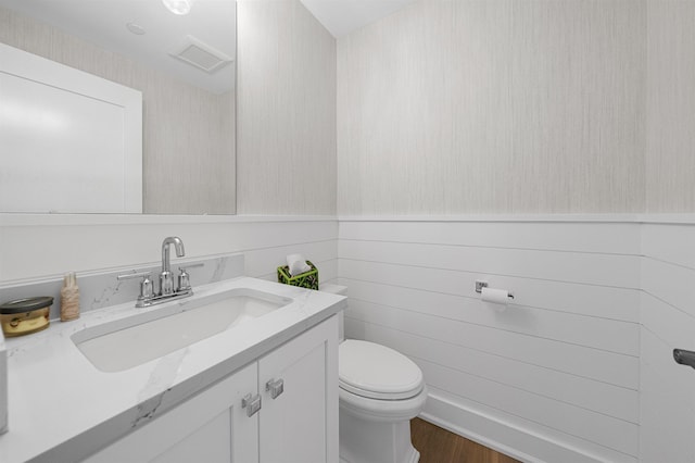 bathroom featuring hardwood / wood-style flooring, vanity, and toilet