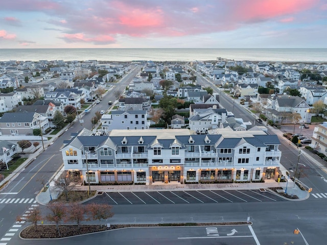 aerial view at dusk featuring a water view