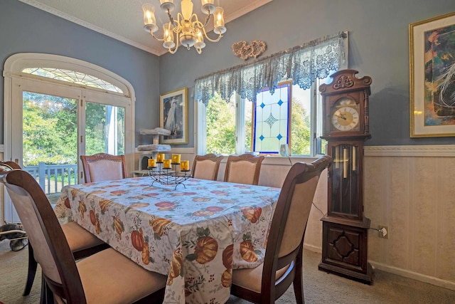 dining area with carpet, a chandelier, and crown molding