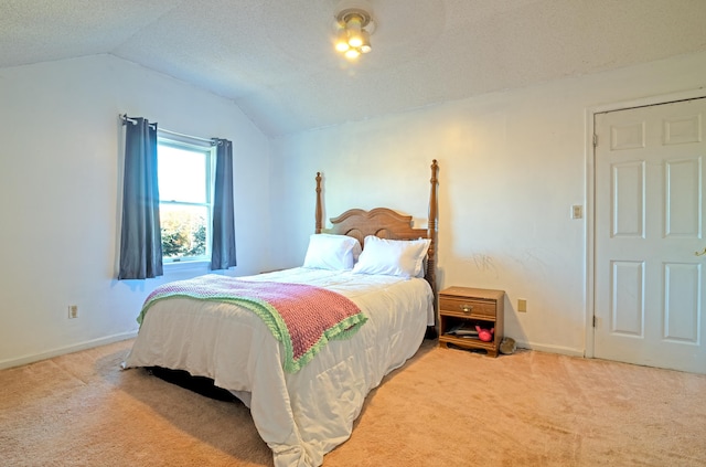 carpeted bedroom featuring a textured ceiling and lofted ceiling