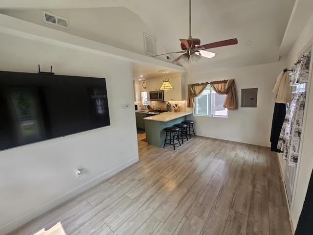704 E Tampa Ave, Villas, NJ 08251 - kitchen featuring a kitchen bar, electric panel, stainless steel microwave, light countertops, and lofted ceiling