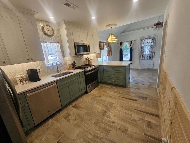 704 E Tampa Ave, Villas, NJ 08251 - kitchen featuring green cabinets, stainless steel appliances, white cabinetry, light countertops, and a peninsula