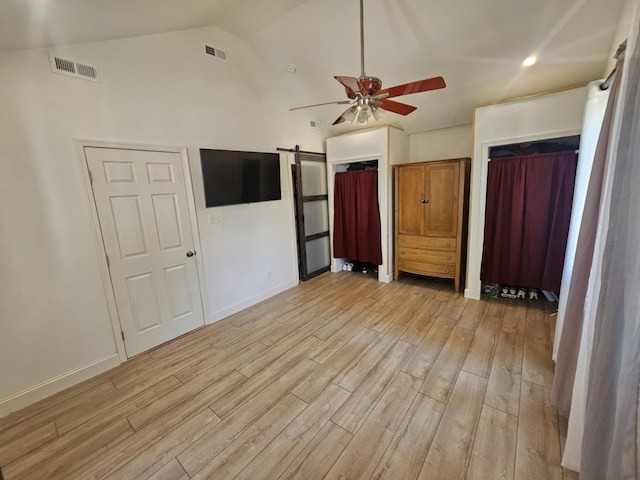 704 E Tampa Ave, Villas, NJ 08251 - unfurnished bedroom featuring light wood-style flooring, a barn door, vaulted ceiling, and ceiling fan