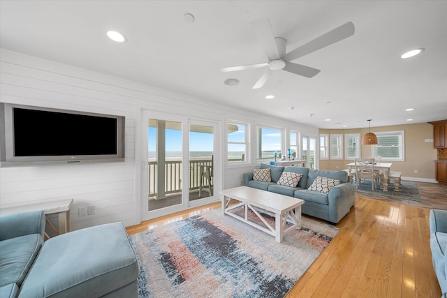 living room with ceiling fan and light hardwood / wood-style flooring