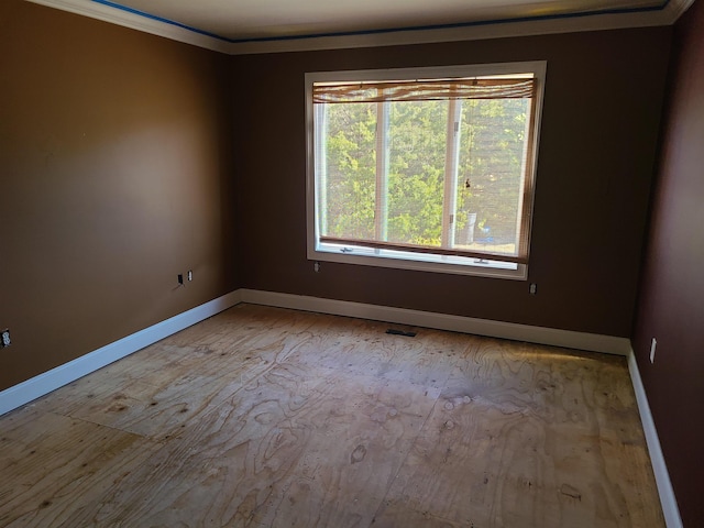 unfurnished room featuring plenty of natural light and crown molding