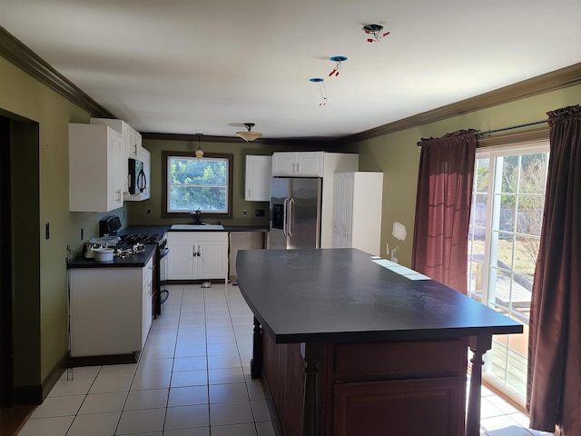 kitchen featuring sink, crown molding, light tile patterned floors, white cabinetry, and stainless steel appliances