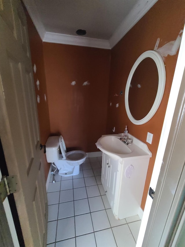 bathroom with tile patterned floors, vanity, toilet, and ornamental molding