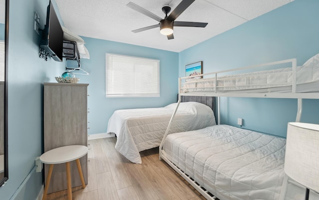 bedroom featuring ceiling fan, baseboards, and wood finished floors