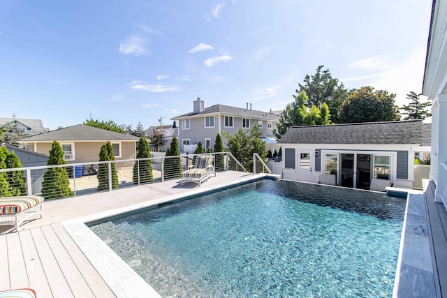 view of pool with a wooden deck and an outbuilding