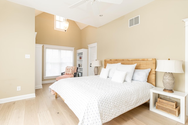 bedroom with ceiling fan, high vaulted ceiling, and light wood-type flooring