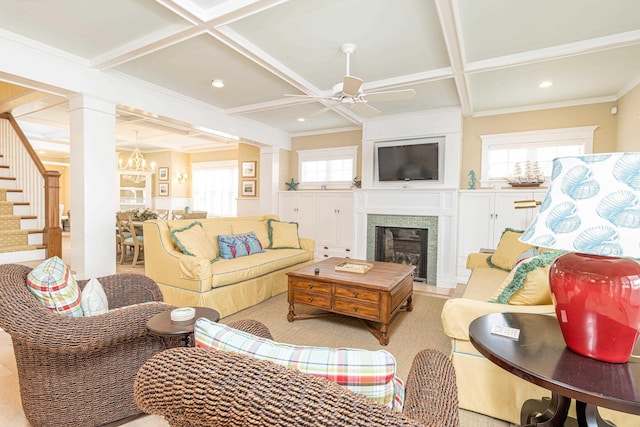 living room featuring coffered ceiling, beam ceiling, ornate columns, a fireplace, and ceiling fan with notable chandelier