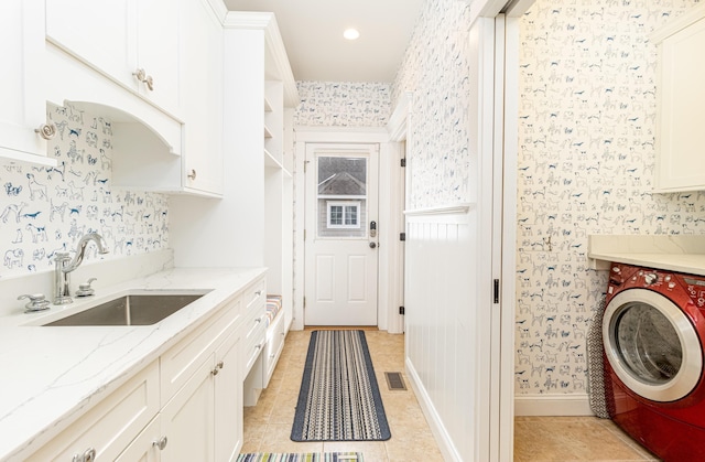 laundry room featuring cabinets, washer / dryer, sink, and light tile patterned floors