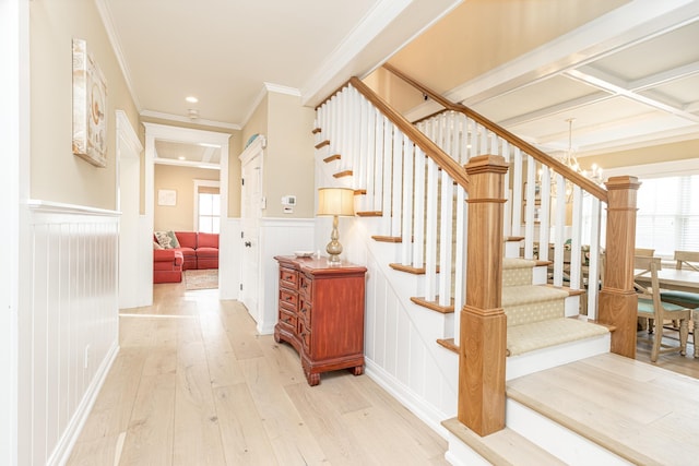 stairs with crown molding, a notable chandelier, hardwood / wood-style flooring, and coffered ceiling