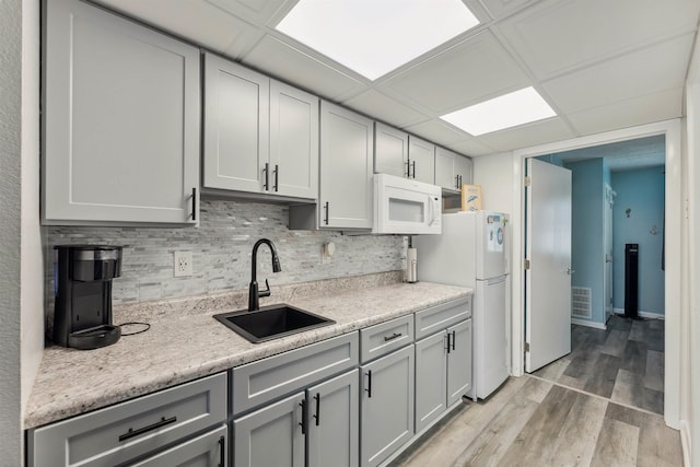 417 E 22nd Ave Unit 101, North Wildwood, NJ 08260 - kitchen with white appliances, gray cabinets, light countertops, tasteful backsplash, and light wood finished floors