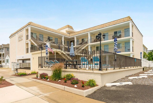 417 E 22nd Ave Unit 101, North Wildwood, NJ 08260 - view of property with stairway and uncovered parking