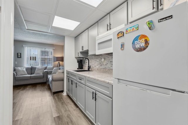 417 E 22nd Ave Unit 101, North Wildwood, NJ 08260 - kitchen with white appliances, light countertops, backsplash, open floor plan, and light wood finished floors