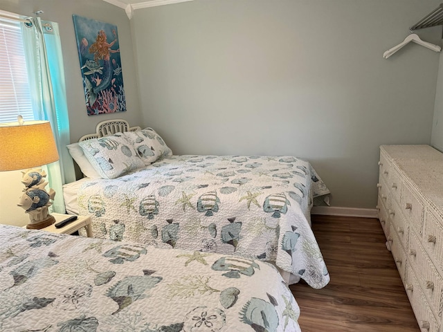 bedroom featuring ornamental molding, wood finished floors, and baseboards