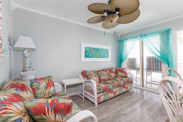 living room featuring ceiling fan, ornamental molding, and wood finished floors