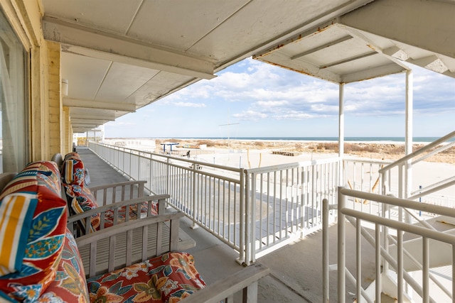 balcony featuring a water view and a beach view