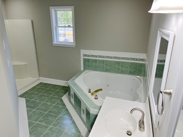 bathroom with tile patterned flooring, sink, and tiled tub