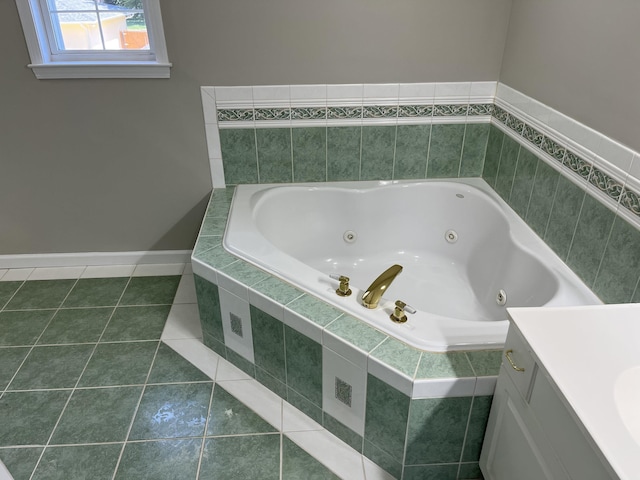 bathroom featuring tile patterned flooring, vanity, and tiled bath