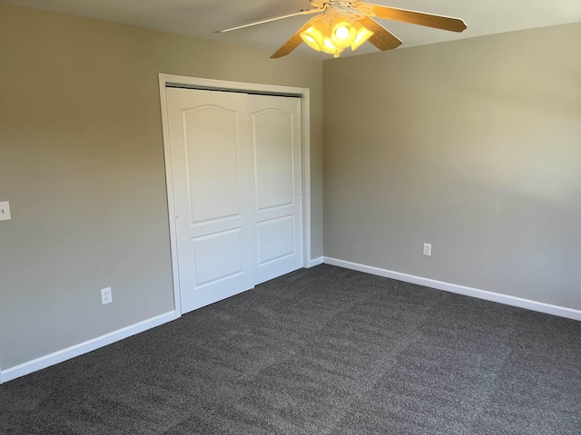 unfurnished bedroom with ceiling fan, a closet, and dark carpet