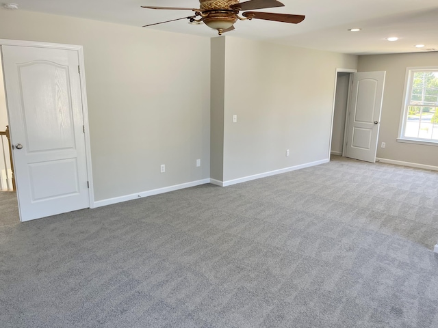 carpeted spare room featuring ceiling fan