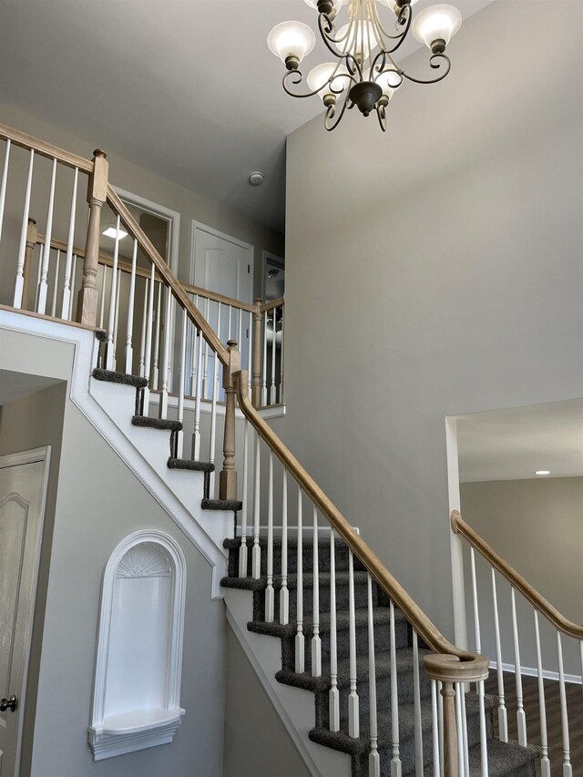 stairway featuring hardwood / wood-style flooring and a notable chandelier