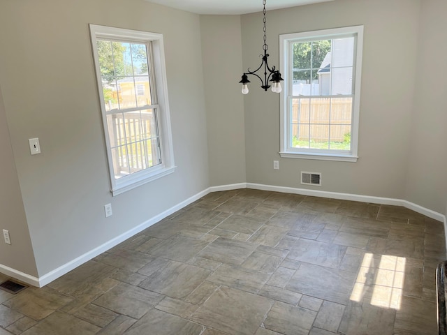 unfurnished dining area featuring an inviting chandelier