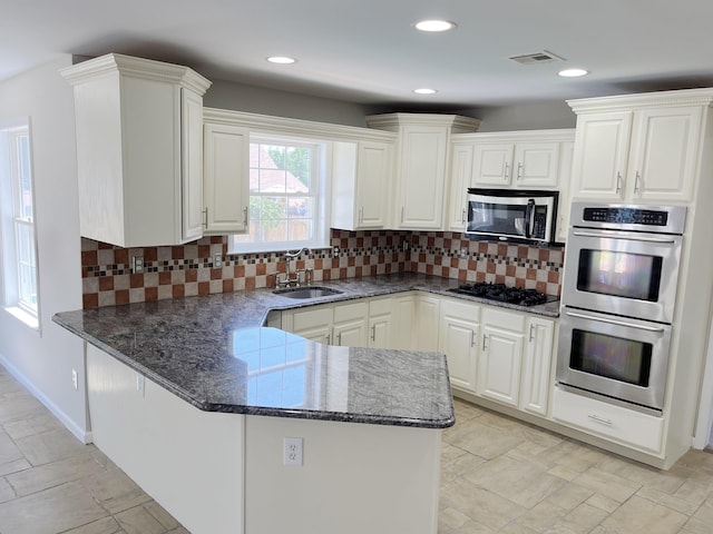 kitchen featuring backsplash, black gas stovetop, double oven, sink, and white cabinets