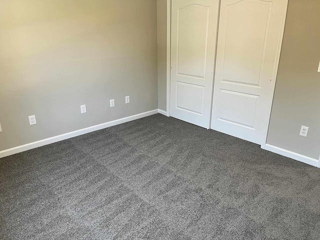 unfurnished bedroom featuring a closet and dark colored carpet