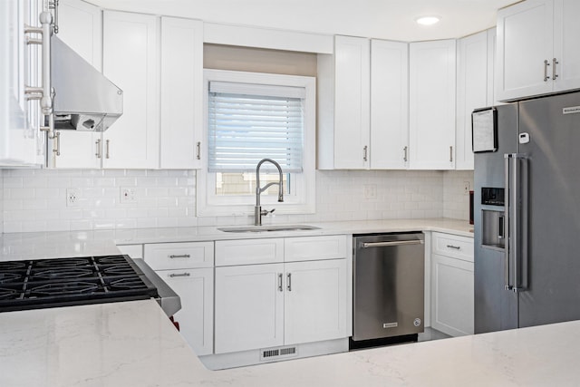kitchen with sink, stainless steel appliances, light stone counters, range hood, and white cabinets