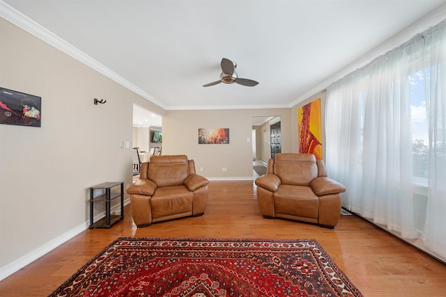 living room with hardwood / wood-style floors, ceiling fan, and crown molding