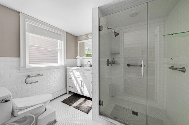 bathroom featuring tile patterned floors, walk in shower, vanity, tile walls, and toilet