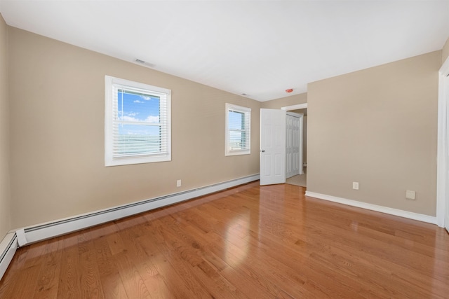 spare room with light hardwood / wood-style floors and a baseboard heating unit