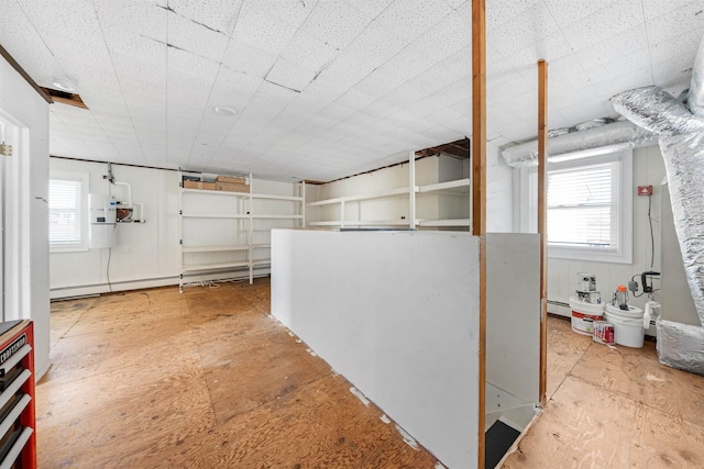basement with baseboard heating and plenty of natural light