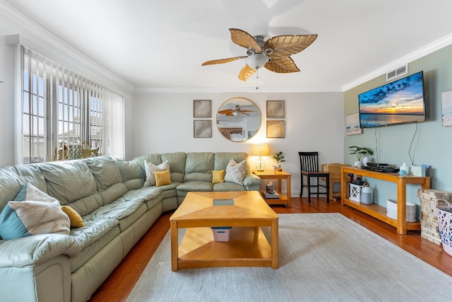 living room with visible vents, ceiling fan, wood finished floors, and crown molding